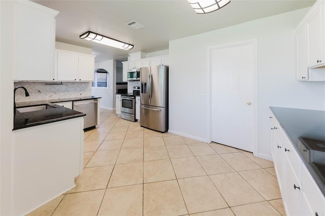 115 Hummingbird Ct, Cedar Creek, TX 78612 - kitchen with appliances with stainless steel finishes, a sink, backsplash, dark countertops, and light tile patterned floors