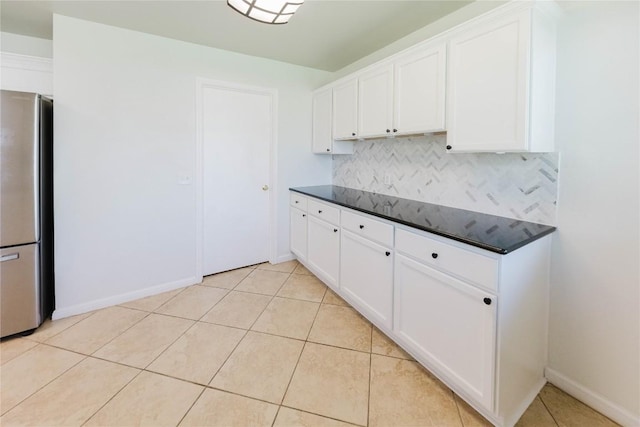 115 Hummingbird Ct, Cedar Creek, TX 78612 - kitchen with freestanding refrigerator, tasteful backsplash, white cabinets, and baseboards