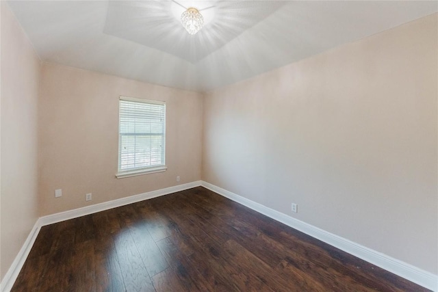 115 Hummingbird Ct, Cedar Creek, TX 78612 - empty room with dark wood-style flooring, baseboards, and a chandelier