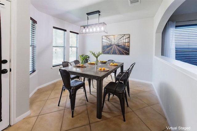 115 Hummingbird Ct, Cedar Creek, TX 78612 - dining room featuring light tile patterned floors, baseboards, and arched walkways