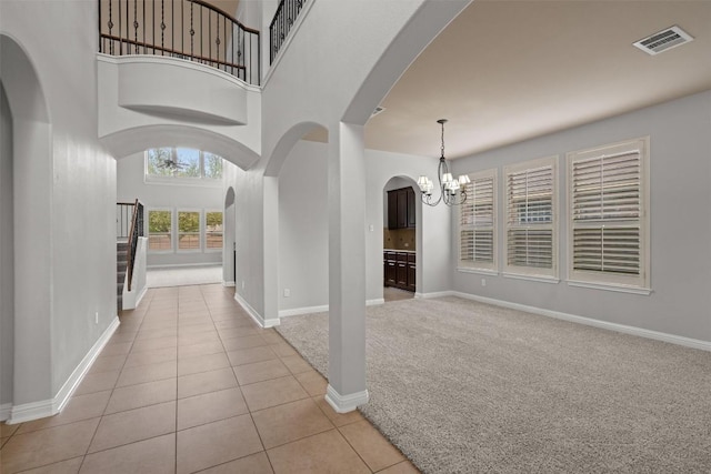 19521 Brue St, Pflugerville, TX 78660 - foyer entrance with arched walkways, a chandelier, light tile patterned flooring, baseboards, and a high ceiling