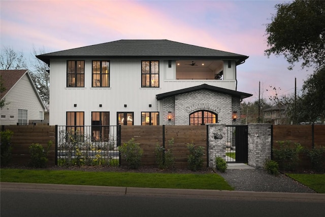 901 Wayside Dr, Austin, TX 78703 - view of front of home featuring a fenced front yard, a gate, roof with shingles, a balcony, and brick siding