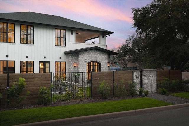901 Wayside Dr, Austin, TX 78703 - back of property at dusk with a balcony, a shingled roof, and board and batten siding