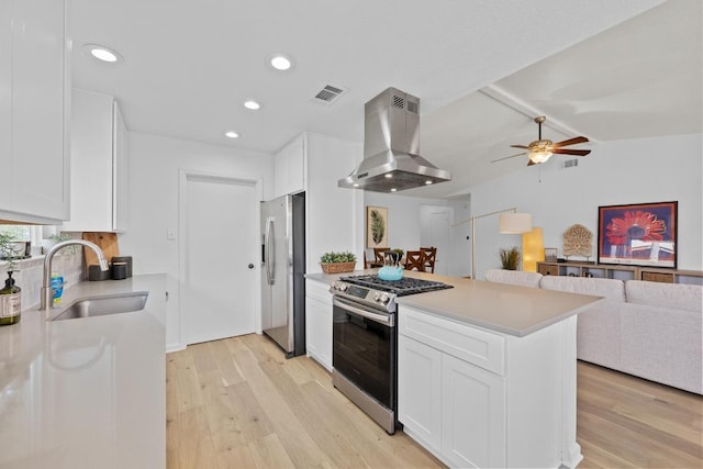 11305 Songbird Cv, Austin, TX 78750 - kitchen with ventilation hood, stainless steel appliances, ceiling fan, light wood-type flooring, and recessed lighting