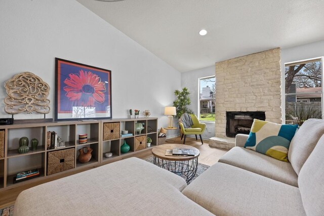 11305 Songbird Cv, Austin, TX 78750 - living room featuring a fireplace, lofted ceiling, wood finished floors, and recessed lighting