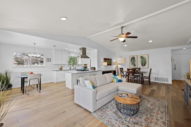 11305 Songbird Cv, Austin, TX 78750 - living area featuring vaulted ceiling, a ceiling fan, light wood-style floors, a chandelier, and recessed lighting