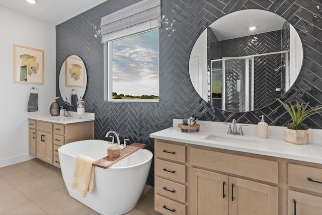 100 Silent Grove Ct, Georgetown, TX 78642 - bathroom featuring two vanities, a freestanding bath, a shower stall, tile patterned floors, and tile walls
