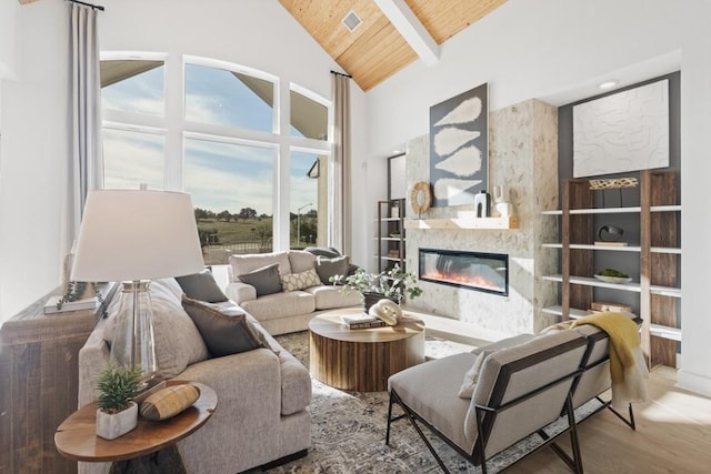 100 Silent Grove Ct, Georgetown, TX 78642 - living room with a wooden ceiling with exposed beams, a glass covered fireplace, high vaulted ceiling, and wood finished floors
