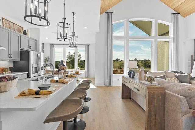100 Silent Grove Ct, Georgetown, TX 78642 - kitchen featuring stainless steel refrigerator with ice dispenser, a chandelier, a breakfast bar, light wood-style floors, and light countertops