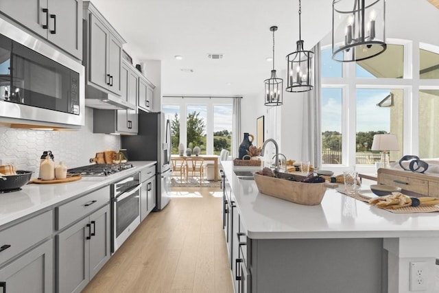 100 Silent Grove Ct, Georgetown, TX 78642 - kitchen with appliances with stainless steel finishes, gray cabinets, a chandelier, and recessed lighting