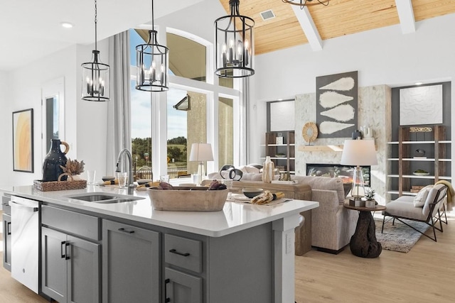 100 Silent Grove Ct, Georgetown, TX 78642 - kitchen with gray cabinetry, dishwashing machine, a kitchen island with sink, a chandelier, and light countertops