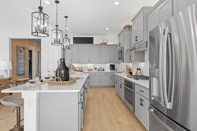 100 Silent Grove Ct, Georgetown, TX 78642 - kitchen featuring appliances with stainless steel finishes, gray cabinets, a chandelier, light countertops, and light wood-style floors