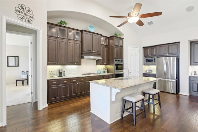 kitchen with visible vents, appliances with stainless steel finishes, dark brown cabinets, a sink, and under cabinet range hood