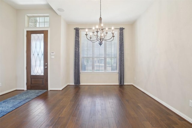 entryway featuring an inviting chandelier, dark wood finished floors, and a wealth of natural light