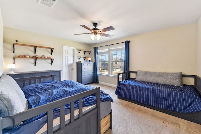 bedroom with baseboards, a ceiling fan, visible vents, and light carpet