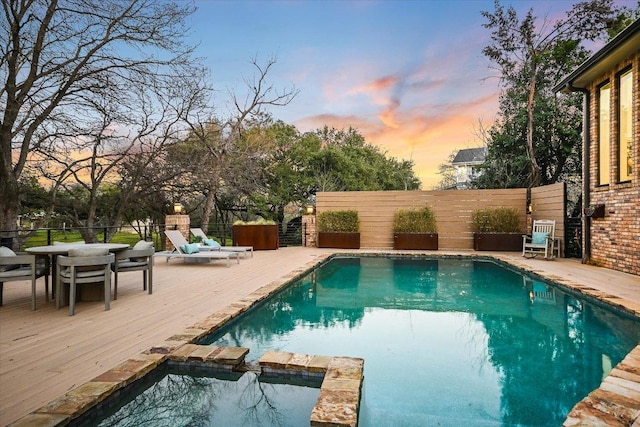 504 Konstanty Cir, Austin, TX 78746 - pool at dusk featuring a deck, a pool with connected hot tub, and outdoor dining area