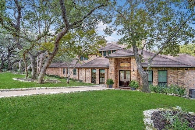 504 Konstanty Cir, Austin, TX 78746 - view of front of property featuring french doors, a front lawn, a tile roof, and brick siding