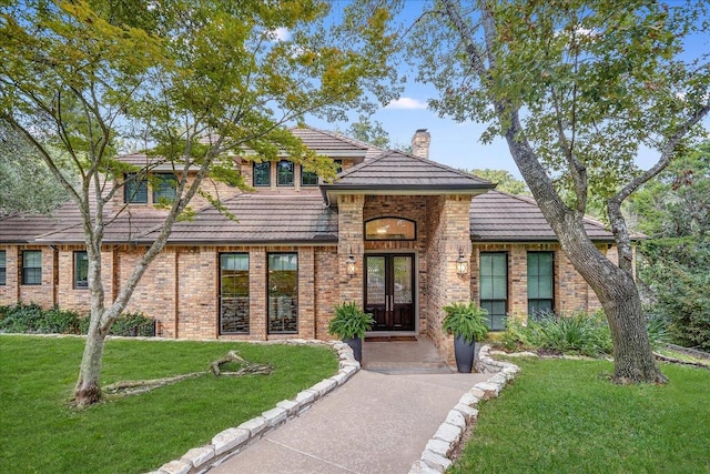 504 Konstanty Cir, Austin, TX 78746 - view of front of home with french doors, a front lawn, a chimney, and brick siding