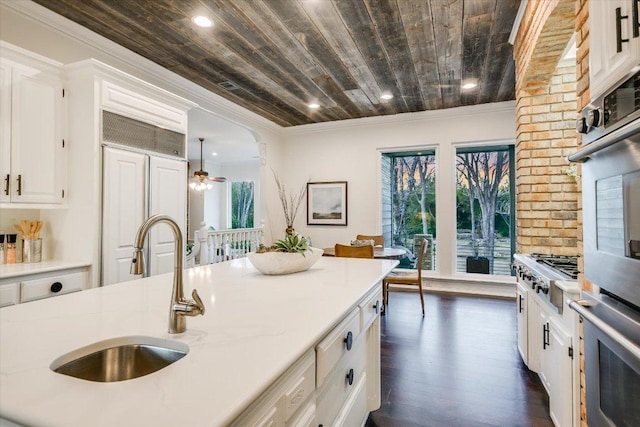 504 Konstanty Cir, Austin, TX 78746 - kitchen featuring stainless steel appliances, wooden ceiling, a sink, white cabinetry, and dark wood-style flooring
