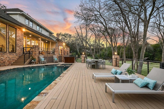 504 Konstanty Cir, Austin, TX 78746 - pool at dusk with stairway, a deck, outdoor dining space, and a pool with connected hot tub