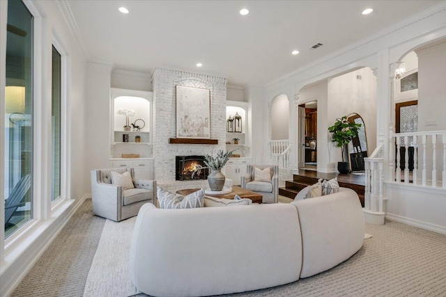 504 Konstanty Cir, Austin, TX 78746 - carpeted living room featuring crown molding, a fireplace, stairs, recessed lighting, and arched walkways