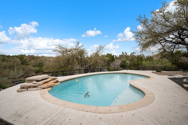 view of swimming pool featuring a patio, fence, and a fenced in pool