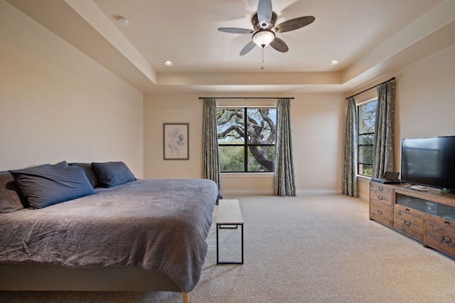 carpeted bedroom with a ceiling fan, a raised ceiling, baseboards, and recessed lighting