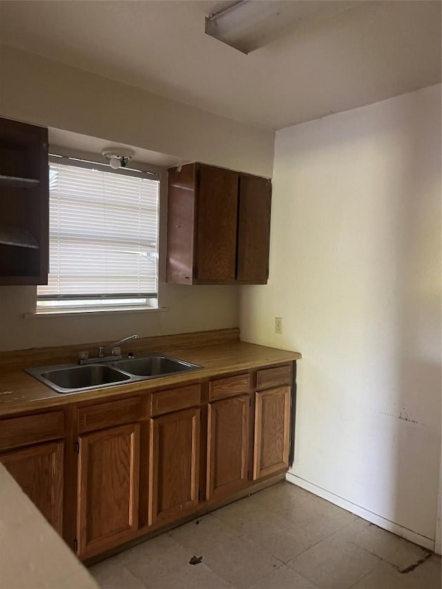 410 Railroad St, San Marcos, TX 78666 - kitchen featuring a sink, open shelves, and brown cabinetry