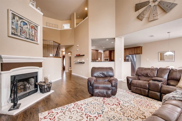 19803 Mallard Pond Trl, Pflugerville, TX 78660 - living room featuring wood finished floors, a fireplace with raised hearth, and a towering ceiling