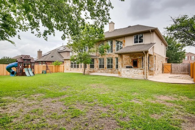 19803 Mallard Pond Trl, Pflugerville, TX 78660 - back of house with a patio, stone siding, a fenced backyard, a chimney, and a playground