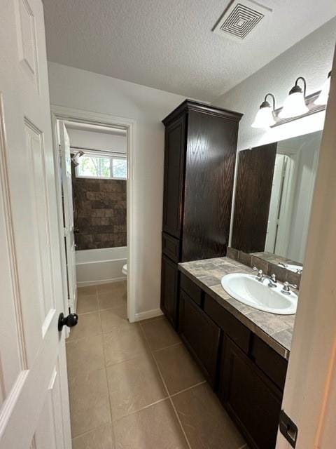 11708 Bittern Holw, Austin, TX 78758 - full bathroom featuring vanity, tile patterned flooring, toilet, a textured ceiling, and bathtub / shower combination