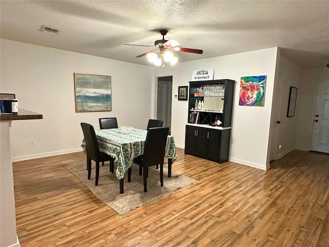 11708 Bittern Holw, Austin, TX 78758 - dining room featuring wood finished floors, a ceiling fan, a textured ceiling, and baseboards