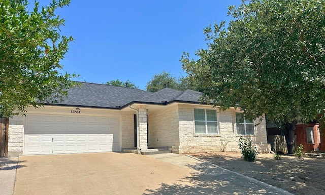 11708 Bittern Holw, Austin, TX 78758 - view of front of house featuring concrete driveway, an attached garage, stone siding, and a shingled roof