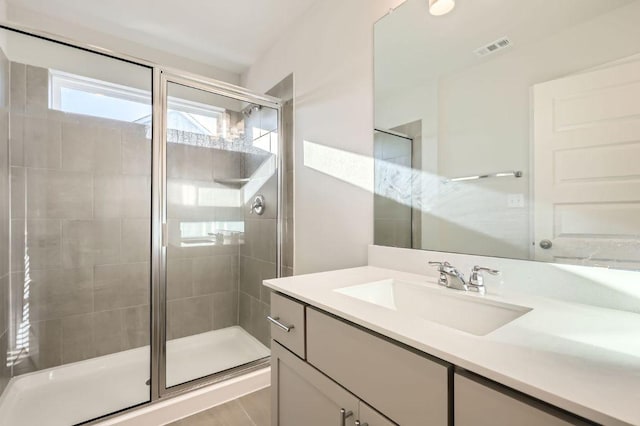 bathroom with vanity, a stall shower, and visible vents