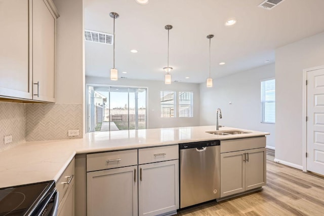 kitchen with a sink, tasteful backsplash, dishwasher, light wood-type flooring, and visible vents