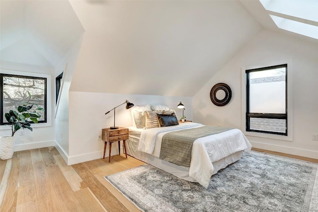 2009 Riverview St, Austin, TX 78702 - bedroom featuring vaulted ceiling, wood finished floors, multiple windows, a skylight, and baseboards