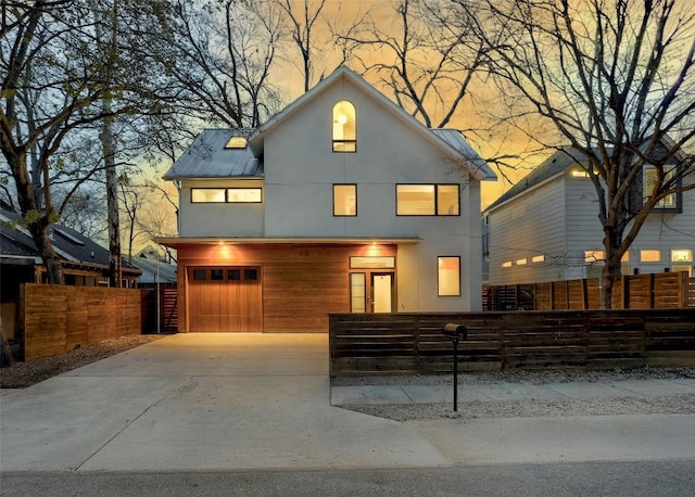 2009 Riverview St, Austin, TX 78702 - view of front of property featuring an attached garage, a fenced front yard, concrete driveway, and stucco siding