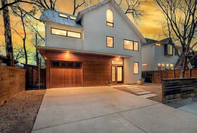 2009 Riverview St, Austin, TX 78702 - modern home featuring a garage, stucco siding, driveway, and a standing seam roof