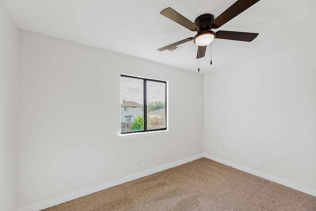 carpeted empty room featuring baseboards and ceiling fan