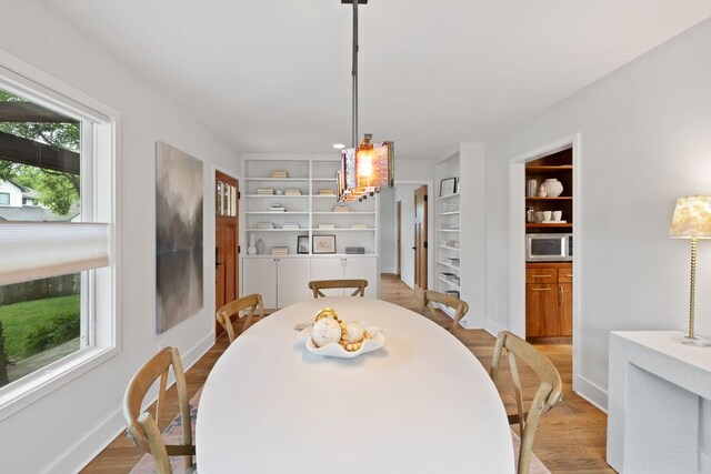 2300 S 3rd St, Austin, TX 78704 - dining space with built in shelves, wood finished floors, and baseboards