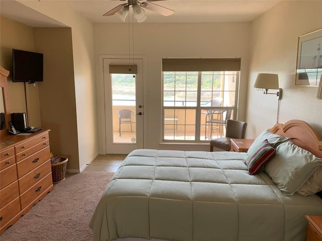 bedroom with light colored carpet, access to exterior, and baseboards