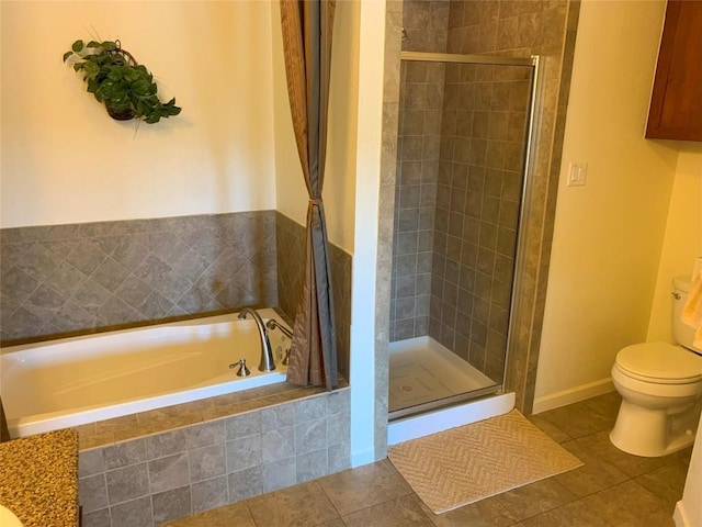 bathroom with a shower stall, tile patterned floors, toilet, and a garden tub