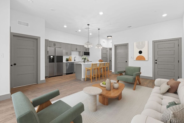 2450 Wickersham Ln Unit 2013, Austin, TX 78741 - living area with light wood-style floors, recessed lighting, a chandelier, and baseboards