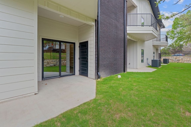 2450 Wickersham Ln Unit 2013, Austin, TX 78741 - view of exterior entry featuring a balcony, a lawn, board and batten siding, brick siding, and central air condition unit