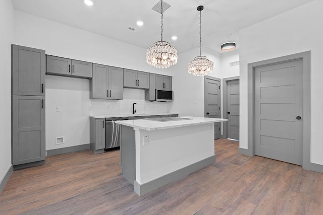 2450 Wickersham Ln Unit 2013, Austin, TX 78741 - kitchen with stainless steel dishwasher, a chandelier, dark wood-type flooring, backsplash, and hanging light fixtures