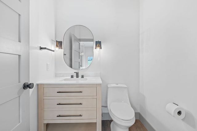 2450 Wickersham Ln Unit 2013, Austin, TX 78741 - bathroom featuring vanity, toilet, and wood finished floors