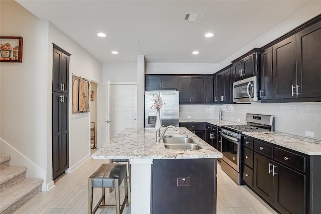 13800 Lyndhurst St Unit 325, Austin, TX 78717 - kitchen with appliances with stainless steel finishes, a sink, backsplash, a kitchen bar, and recessed lighting