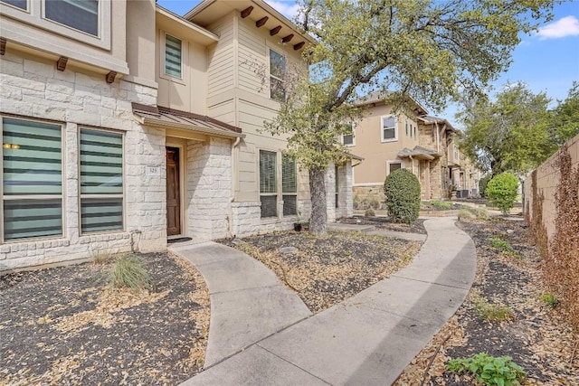 13800 Lyndhurst St Unit 325, Austin, TX 78717 - view of exterior entry with stone siding and a standing seam roof