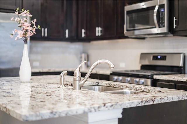13800 Lyndhurst St Unit 325, Austin, TX 78717 - kitchen featuring stainless steel appliances, a sink, dark brown cabinetry, and light stone counters