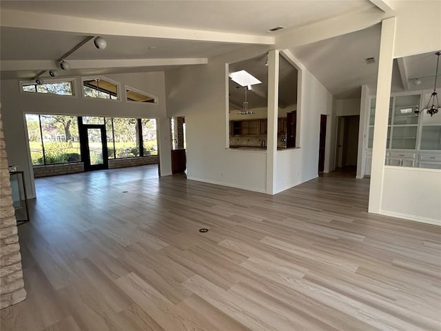 712 Rolling Green Dr, Lakeway, TX 78734 - unfurnished living room featuring baseboards, beamed ceiling, visible vents, and wood finished floors